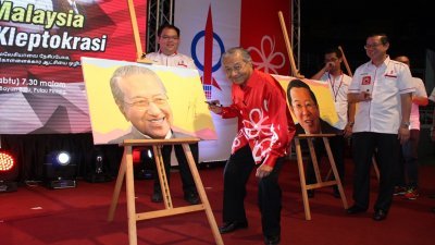 马哈迪（左）在晚宴上为其肖像签名留念，5幅希盟领袖肖像最终以23万令吉拍卖售出。左2为林冠英。