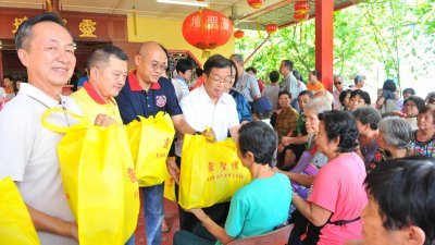 陈有发（左起）、陈顺民、潘劲福以及陈国伟，颁发220份红包和日常食品予乐龄贫困人士。 （摄影：陈为康）