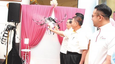 “黑斑蚊，喷死你！”，林冠英（左起）、槟州行政议员林峰成，在黑斑蚊模型上喷射灭蚊剂，象征与黑斑蚊宣战。