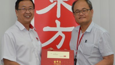 刘华才（左）赠送月饼予本报高级总经理 （编辑和广告）兼数码媒体总监陈利良。