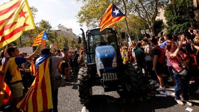 加泰罗尼亚农民周五驾著拖拉机，穿过巴塞罗那中心，支持举行独立公投，民众在路旁举旗欢迎。