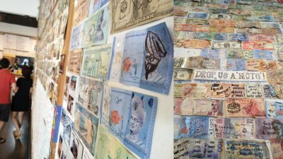 多张我国钞票也遭人涂鸦之后，被贴在墙壁上。