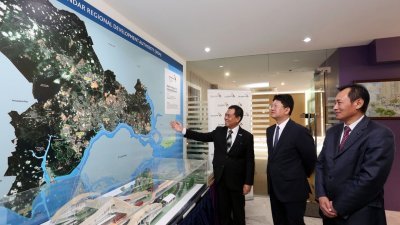 依斯迈（左起）、白天和大马中国银行行长王宏伟参观马来西亚依斯干达特区地图。（摄影：刘维杰）