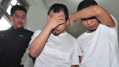2嫌犯面对摄影镜头时以手掩脸。（摄影：杨金森）