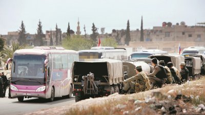 在跟叙叙利亚政府达成撤离协议后，反政府军和他们的家眷，陆续乘巴士离开杜马镇。