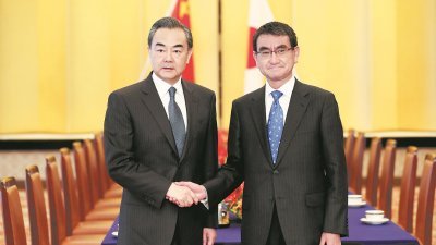 中国外交部长王毅（左）周日抵达东京，与日本外相河野太郎会面。王毅在日本逗留3天，将与河野共同主持停滞了7年多中日经济高层对话。