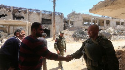叙利亚政府军重夺东古塔后，周一安排外国传媒到被指发生化武袭击的杜马镇采访。在现场，叙利亚安全部队人员和俄罗斯军人就在附近巡逻，一名叙利亚男子和俄国士兵握手。