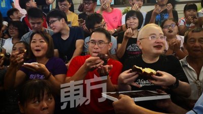 魏家祥（右2起）与林添顺和民众一同吃肮脏包，一同创下最多永平居民吃肮脏包的纪录。