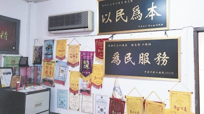 张志坚的服务中心内挂满了服务牌匾和感谢状，服务获得选民肯定。