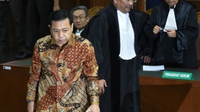 印尼前国会议长塞特亚（左）被控在电子身份证计划中，私吞2859万令吉，周二在雅加达法庭被判处坐牢15年。