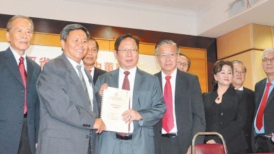 由诗巫省长萧查尔斯(左3)代表移交宣誓书予诗巫省独中董联会新届主席刘利民(左4)。