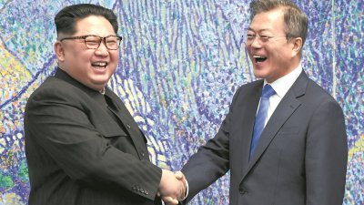 朝鲜最高领导人金正恩（左）周五跨越韩朝边界的军事分界线，与韩国总统文在寅在板门店韩方一侧的“和平之家”，举行历史性会晤。两人在会谈期间握手让媒体记者拍照时，开怀大笑，现场气氛显得轻松。