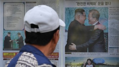 对于两国领导人的历史性会晤，韩朝媒体纷纷给予高度评价。在首尔人行道上，一名民众经过贴有相关报导的布告墙。
