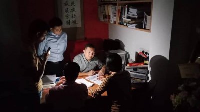 黄思汉（右）的服务中心周三晚上也停电，只能抹黑接见选民。