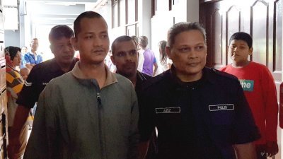 曹达里（前左）与达斯甘海亚（后）被警方押往怡保反贪污法庭聆听判决。