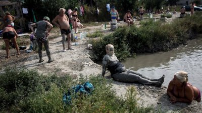 热浪席卷北半球，在塞尔维亚首都贝尔格莱德，有民众做泥巴日光浴，将泥巴涂抹全身来降温。有研究显示，人为因素造成的全球暖化和地球表面温度自然上升合并发威，异常炎热的天气将持续至2022年。-法新社-