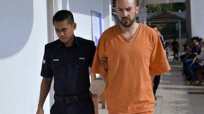 纽西兰籍被告克勒威尔身穿橙色囚服，被带上法庭。