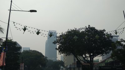 烟霾导致槟州的天空灰濛蒙，空气中弥漫著一股烧焦味，远处的建筑物只剩下“影子”。