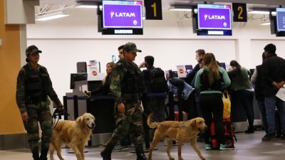 秘鲁卡亚俄省的查韦斯机场，周四可见有军警人员牵著警犬，在智利南美航空公司的登机手续柜台附近巡逻。智利南美航空公司表示，因炸弹威胁而受影响的乘客将会转至其他的航班。-路透社-