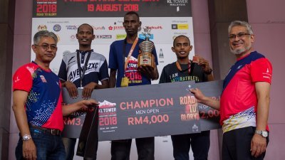 卡立沙末（右）和罗兹兰莫哈末（左）颁发奖品予“2018年 吉隆坡塔国际马拉松挑战”男子公开赛组别中的胜出者。