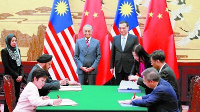 敦马哈迪（站者，左2）及李克强（站者，左3）共同见证马中签署5项协议，其中3项涉及农 业与原产品开发技术的合作，另外2项协议则为延长双边货币互换及会计与稽查监管上的合 作。左为马来西亚国家银行总裁拿督诺珊西亚及中国人民银行行长易纲（右）。