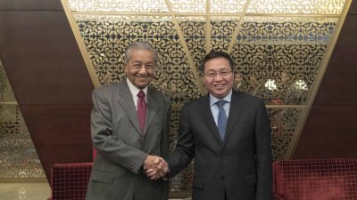 马哈迪在北京与中国银行董事长陈四清（右）见面交流。