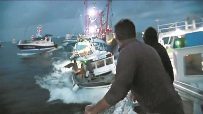 为了阻止、并抗议英国渔民对扇贝的过度捕捞，超过35艘法国渔船趁夜“突袭”包围了作业中的5艘英籍船只。根据视频，两名法国渔民（背向镜头者），其中一人（右）待英国渔船驶近时，向对方投掷疑似石头的物体。