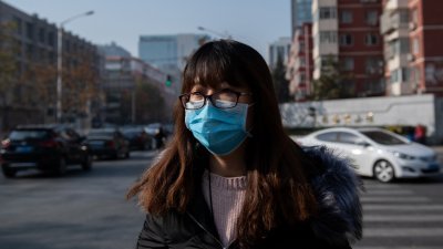 北京一名女市民戴著口罩出门，防范空气污染影响健康。