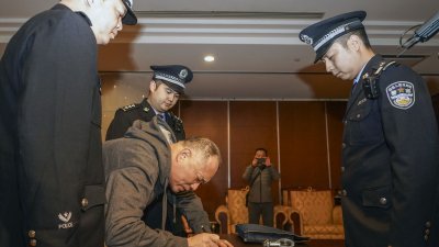 上个月14日，“红通”逃犯郑泉官被从美国强制遣返，在北京首都机场签署文件。
