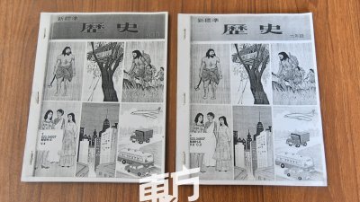 陈亚才向记者展示其收集的小学历史课本，作为研究工作的一部分。
