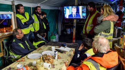 “黄背心”示威者在法国北部蒙塔邦的路边帐篷下收看总统马克龙的电视演说。日前当地的示威者封锁一个油库，以抗议政府提高油价。