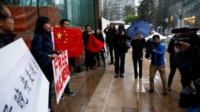 孟晚舟的支持者在温哥华不列颠哥伦比亚省，最高法院前举起大字报和中国国旗示威，声援前者。