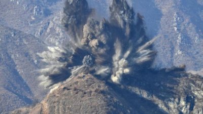 韩国国防部发布的照片显示，朝鲜非军事区内的一处哨所被炸毁，喷发出碎石及滚滚浓烟。