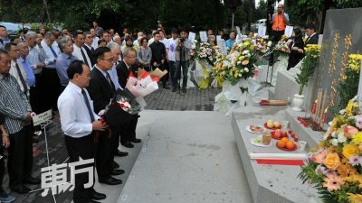 陈大锦（左起）、刘志文、杜乾焕、陈凯希在林连玉墓前，对其献花致敬。 （摄影：连国强）