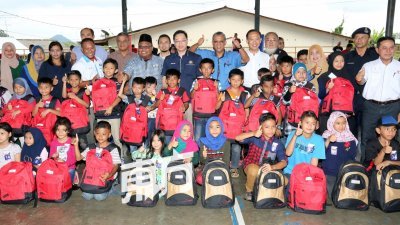 潘伟斯（第3排左7起）和峇德鲁赠送开学用品给200名小学生。（摄影：刘维杰）
