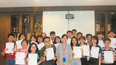 高中统考优秀考生在领取成绩后，高兴地与坤成中学校长蔡莉莉（前排左4）合照。