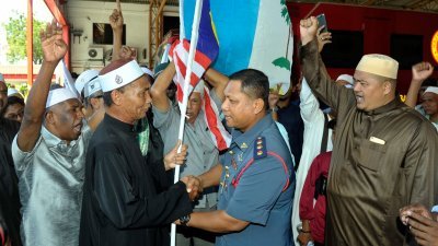 槟州马来青年组织主席尤索夫（左2起）移交国旗给依斯迈， 并由阿兹米等人陪同。（摄影：蔡开国）