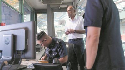 尚穆根（中）周四上午走访新加坡兀兰关卡，向媒体透露 正在探讨如何让兀兰关卡承载更多旅客。 （图取自《海峡时报》）