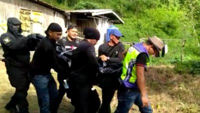 警方将被击毙的菲律宾籍嫌犯，搬出木屋。