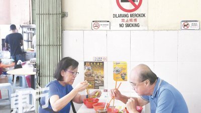 隆市大部分茶餐室已经张贴符合卫生部指定尺寸的禁烟告示 牌，一些商家更早在数个月前，便开始“训练”烟民到户外 吸烟，以便提早适应禁令，避免因小失大。（摄影：伍信隆）