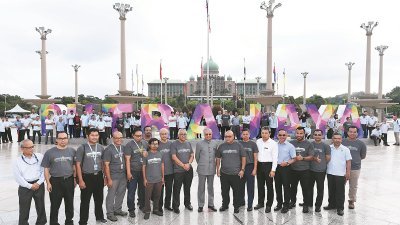 马哈迪（中）为“布城”新雕塑开幕后，与布城机构的员工在雕塑前合影。