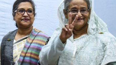 寻求连任的孟加拉国总理哈西娜于周日投票后，向传媒比出象征“胜利”的V手势。
