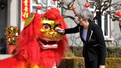 英国首相特丽莎梅周四在北京出席在英国驻华大使官邸举办的文化招待会，她为舞狮点睛。