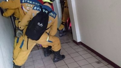 消防人员在云门翠堤大楼内搜寻，由于大楼严重倾斜，他们必须斜著身子，在大楼内艰难行走。