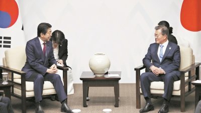 日本首相安倍晋三（左）周五在平昌，与韩国总统文在寅举行会谈。