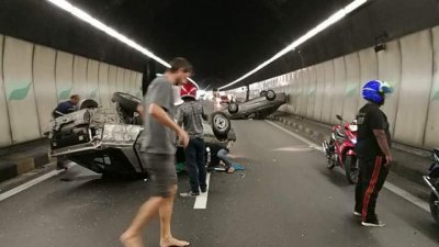 两辆涉祸轿车是在途经隧道时，彼此不知何故发生碰撞，结果双双翻覆。