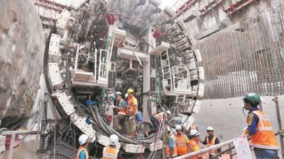 可变密度隧道掘地机就像是小型流水线工厂，可容纳20名工人操作机器，图为工人为掘进机安装电缆。
