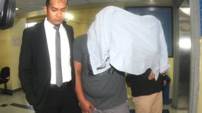 莫哈末阿拉查(左2起)及阿玆米再纳在警员的押送下抵达法庭，两人皆以外套遮头，以避开媒体镜头。（摄影：锺佩佩）