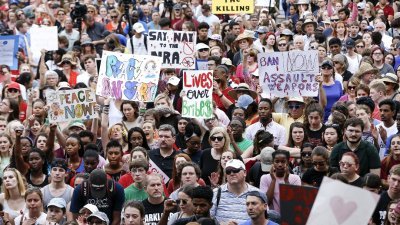 在佛州首府塔拉哈西的州议会大楼外，大批学生和家长高举大字报，抗议共和党控制的州议会拒绝讨论禁止突击步枪和大型弹匣的提案。-法新社-
