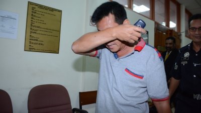 制冰厂董事陈祥璧（译音）被控非法接驳水管及偷取水务局的水源，在法庭认罪后掩脸步离法庭。